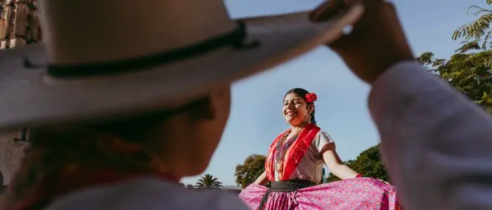 Mexicaine en tenue traditionnelle saluée par une personne et son chapeau